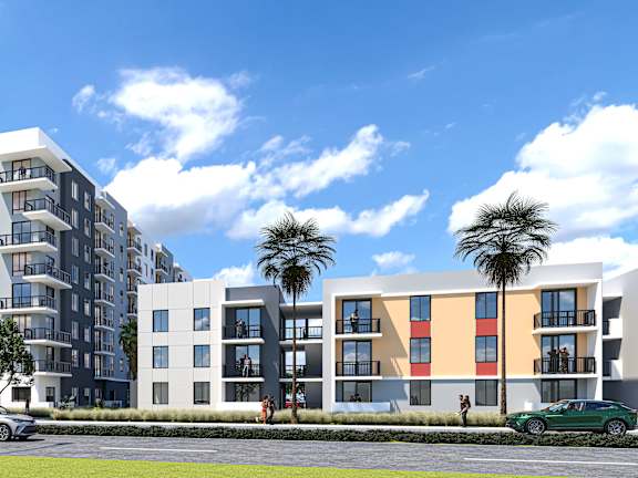 A modern apartment building with a grey car parked in front.