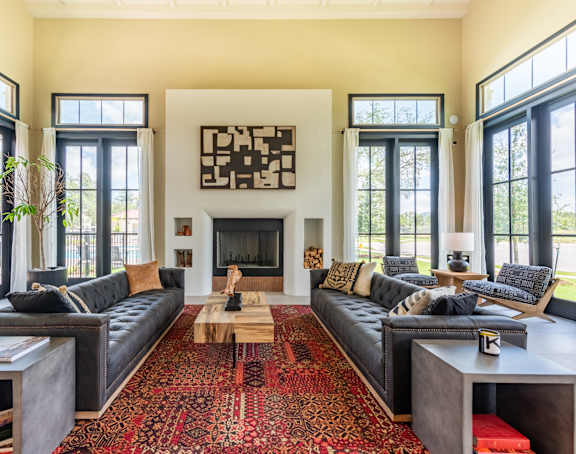 a living room with a fireplace and large windows