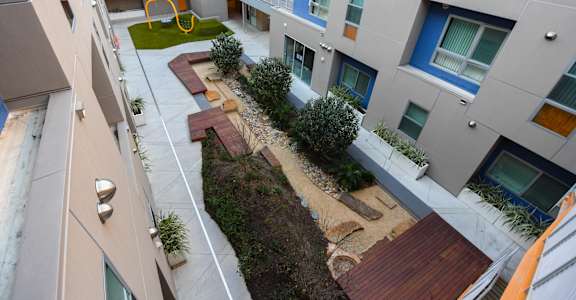 A modern apartment complex with a playground in the courtyard.