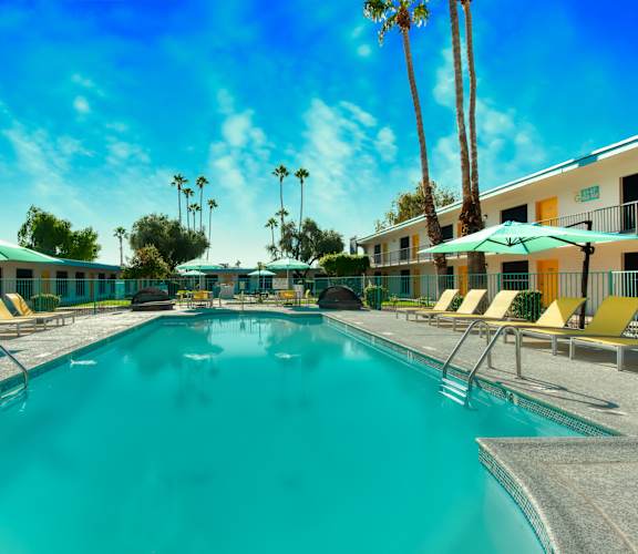 A large swimming pool surrounded by lounge chairs and umbrellas. at The Link Apartments, Mesa, 85201