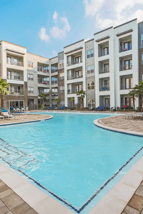 A swimming pool in front of a residential building.