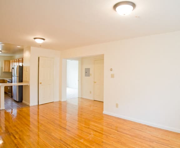 living room with hardwood floors and white walls and view of kitchen