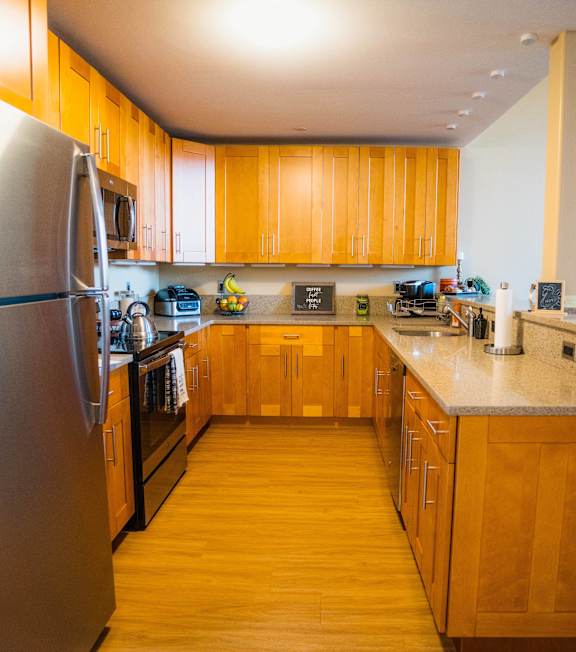 a kitchen with wooden cabinets and stainless steel appliances at Ponemah Mills in Taftville, CT, 06380