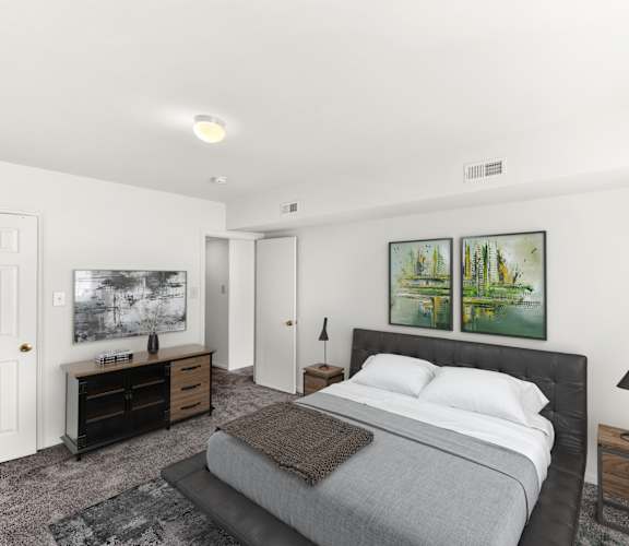 a white bedroom with a bed and two paintings on the wall