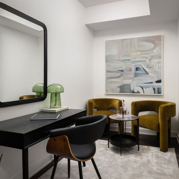 a room with a desk and chairs and a large mirror