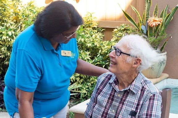 a woman is petting an elderly man