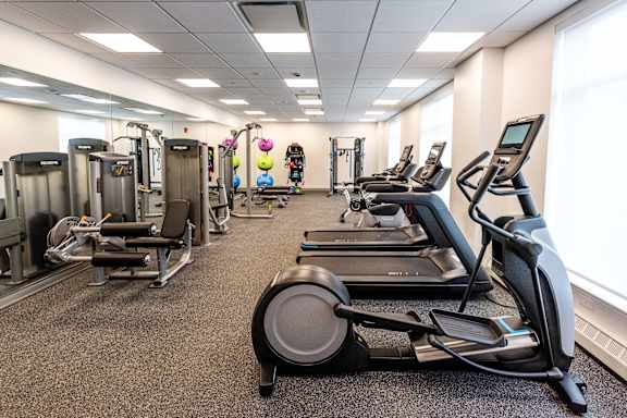 A gym with treadmills, elliptical machines, and other cardio equipment.