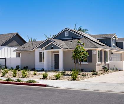 A row of houses with a clear blue sky above them.