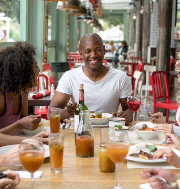 a group of people sitting around a table eating at a restaurant