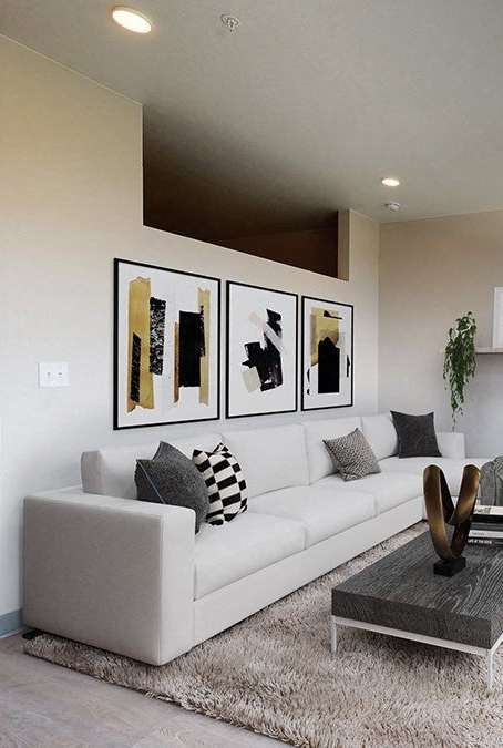 A modern living room with a white couch and a glass coffee table.