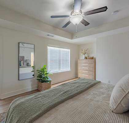 a bedroom with a large bed and a ceiling fan