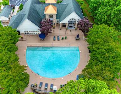 an overhead view of a swimming pool in front of a house