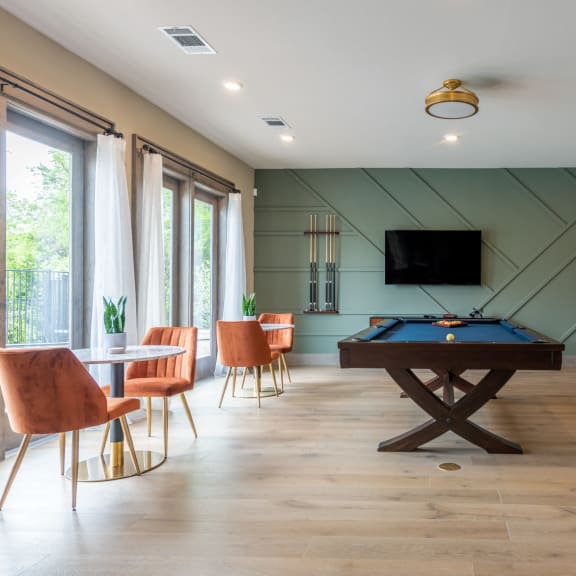 a game room with a pool table and a tv