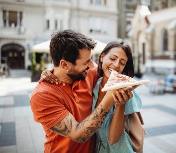 couple eating pizza while out on the town