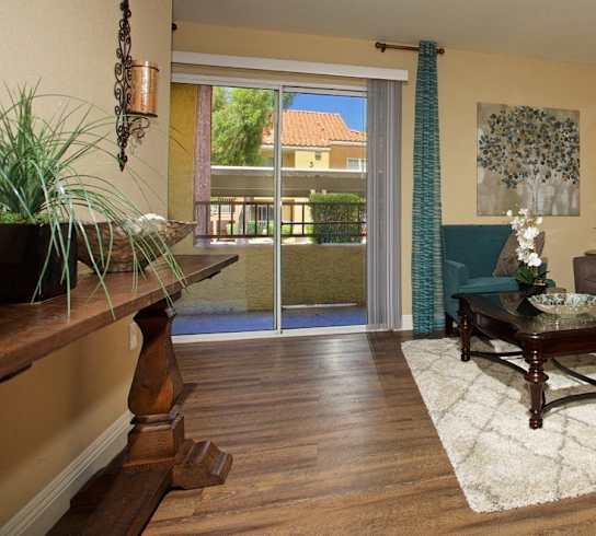 A living room with a couch, a table, and a plant.