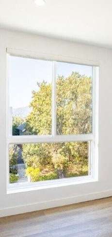 A room with a large window overlooking a tree-filled landscape.