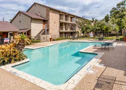 A swimming pool in a residential area with a building in the background.