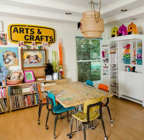 A room filled with arts and crafts supplies and a table with chairs.