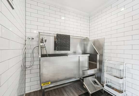 A stainless steel kitchen sink with a drainboard and a dish rack.
