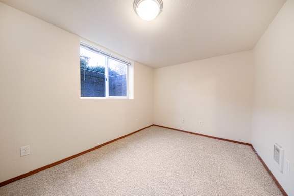 A room with a window and carpeted floor.
