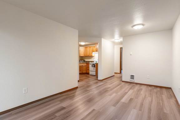 A room with wooden flooring and white walls.