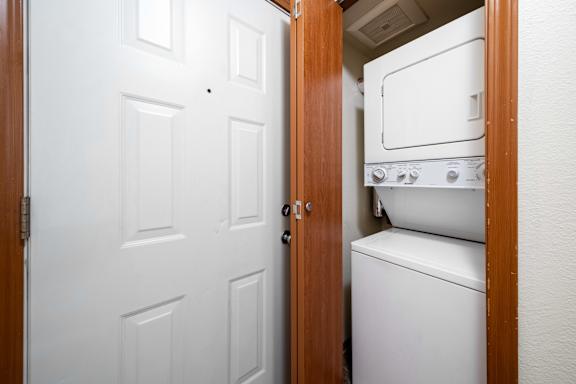 A white washing machine is in a small room.