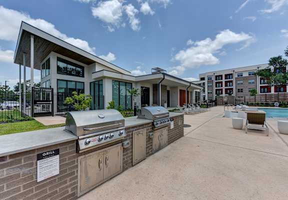 A modern building with a grill area in front. at Bridge at Saffron, Austin, TX