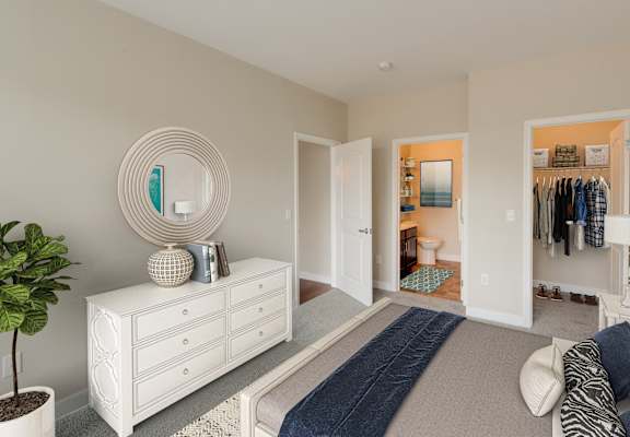 a bedroom with a white dresser and a bed