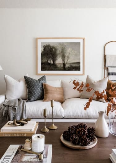 a living room with a white couch and a painting on the wall at Bradford Gwinnett Apartments in Norcross, 30071