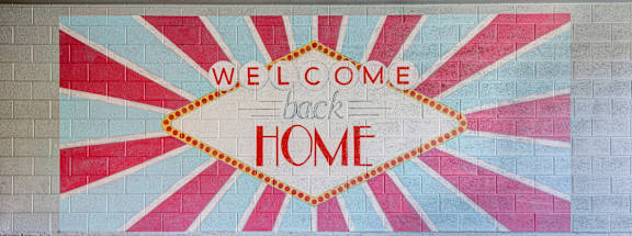 A mural on a wall welcomes people back home.