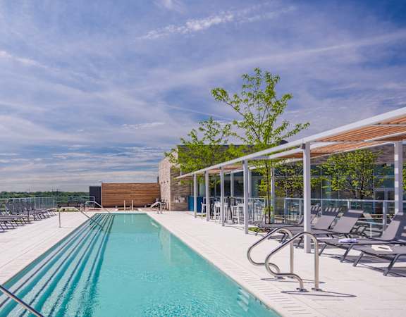a swimming pool with lounge chairs and a building in the background