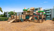 Thumbnail 4 of 30 - a playground with a playset and slides in front of a building