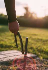 A person's hand holding a stick with a red substance on it.