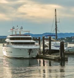 a large white yacht is docked next to a small white boat