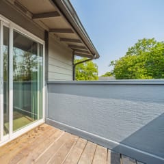 a balcony with glass sliding doors and a kitchen in the background