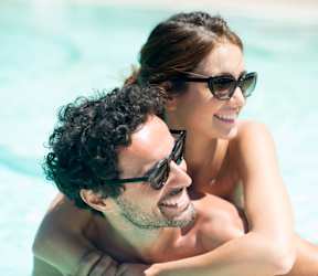 A man and a woman are enjoying their time in a swimming pool.