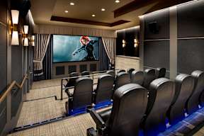 a large screening room with rows of chairs and a large screen