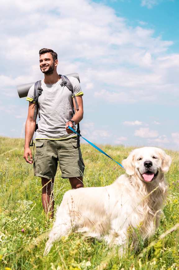 a man standing in a field with his dog