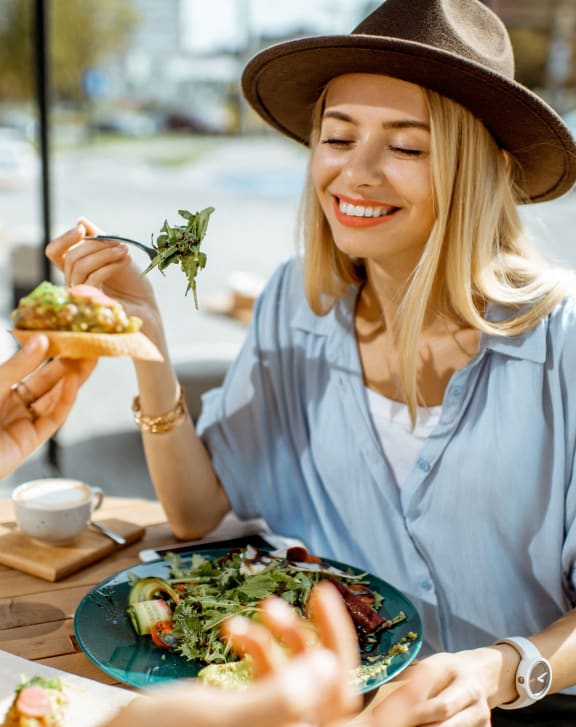 two women sitting at a table eating food