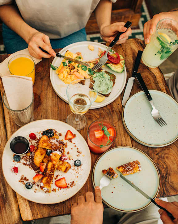 A group of people enjoying a meal together at a wooden table. at Alister Morristown, Morristown, 07960