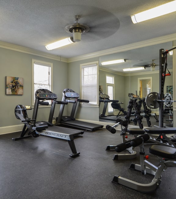 a gym with exercise machines and a ceiling fan