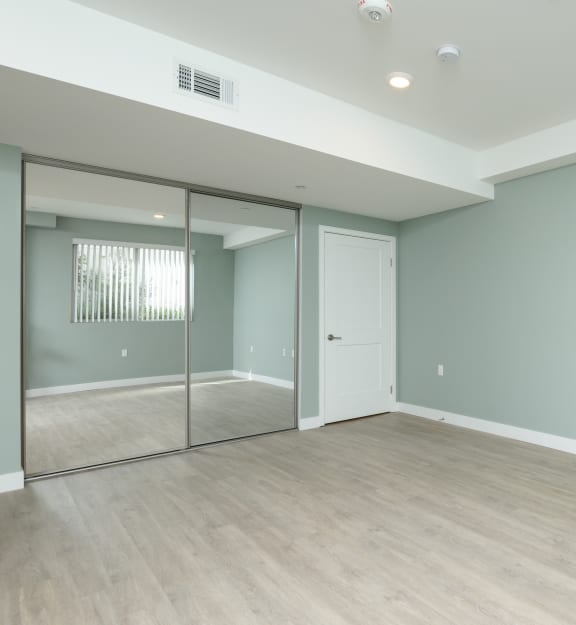 an empty room with a sliding glass door and a hard wood floor
