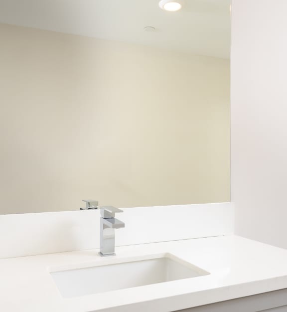 a white bathroom with a sink and a mirror