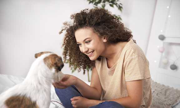 a boy and a dog laying on a bed reading a book