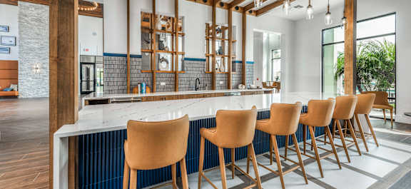 A modern dining room with a long table and chairs at Stillwater Lakes Apartments, Kissimmee, Florida