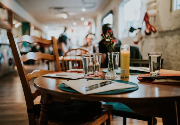 a dining table with a glass of beer and a menu on it