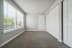 a bedroom with a large window and a carpeted floor