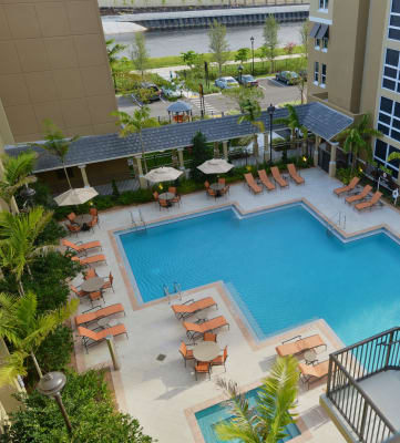 an overhead view of a resort style pool with lounge chairs and umbrellas