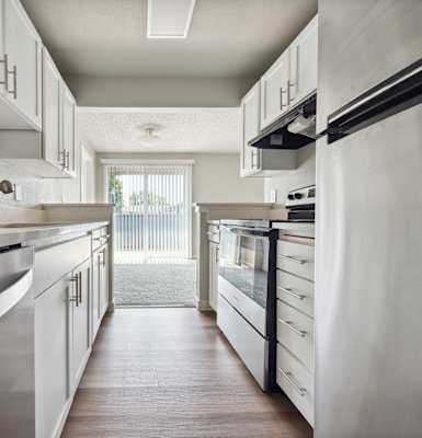 a kitchen with white cabinets and stainless steel appliances