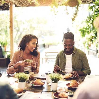 people sitting around a table eating food at a restaurant